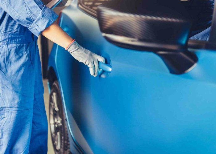 Car mechanic opening side door to maintenance vehicle check for customer claim order in auto repair shop garage. Internal repair service. People occupation business job. Automobile technician industry
