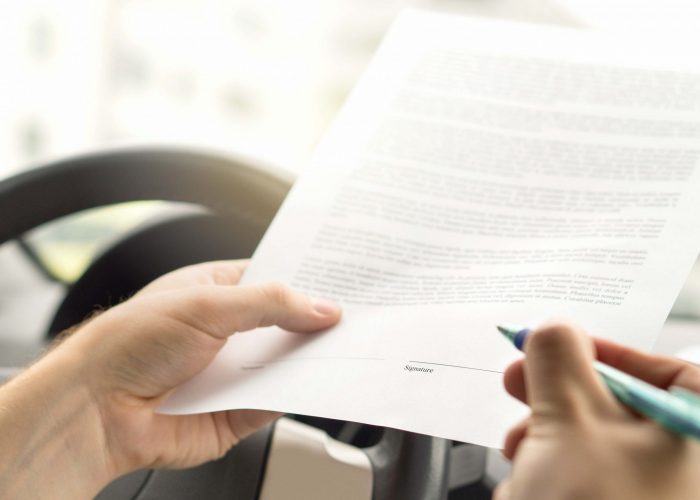 Signing lease or buying new or used car. Man about to write autograph to legal document. Motor vehicle insurance agreement. Rental contract paper.